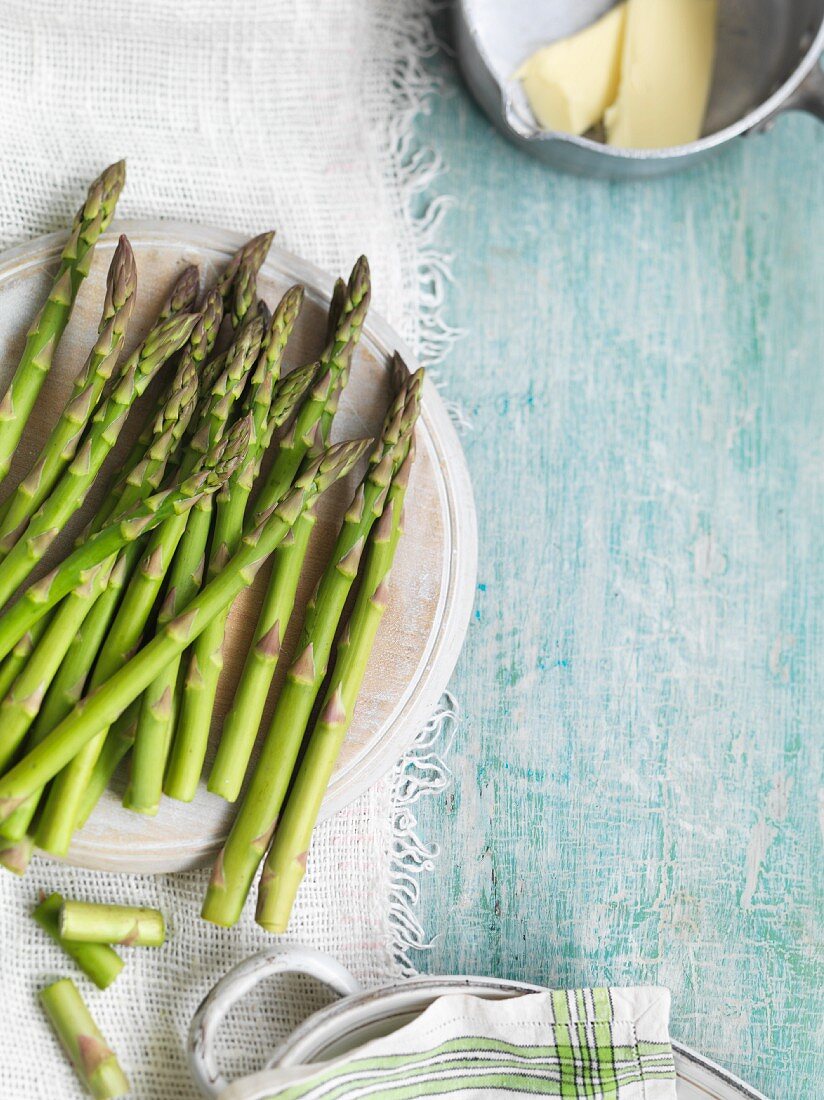 Green asparagus on a plate and butter in a saucepan
