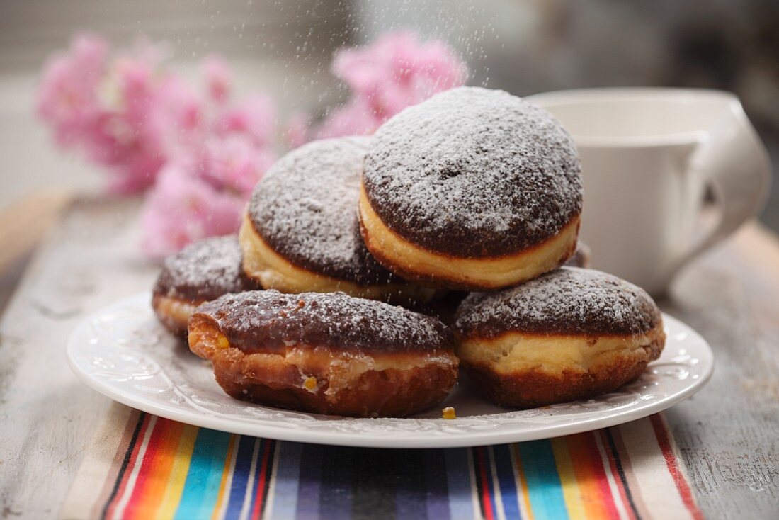 A plate of doughnuts dusted with icing sugar