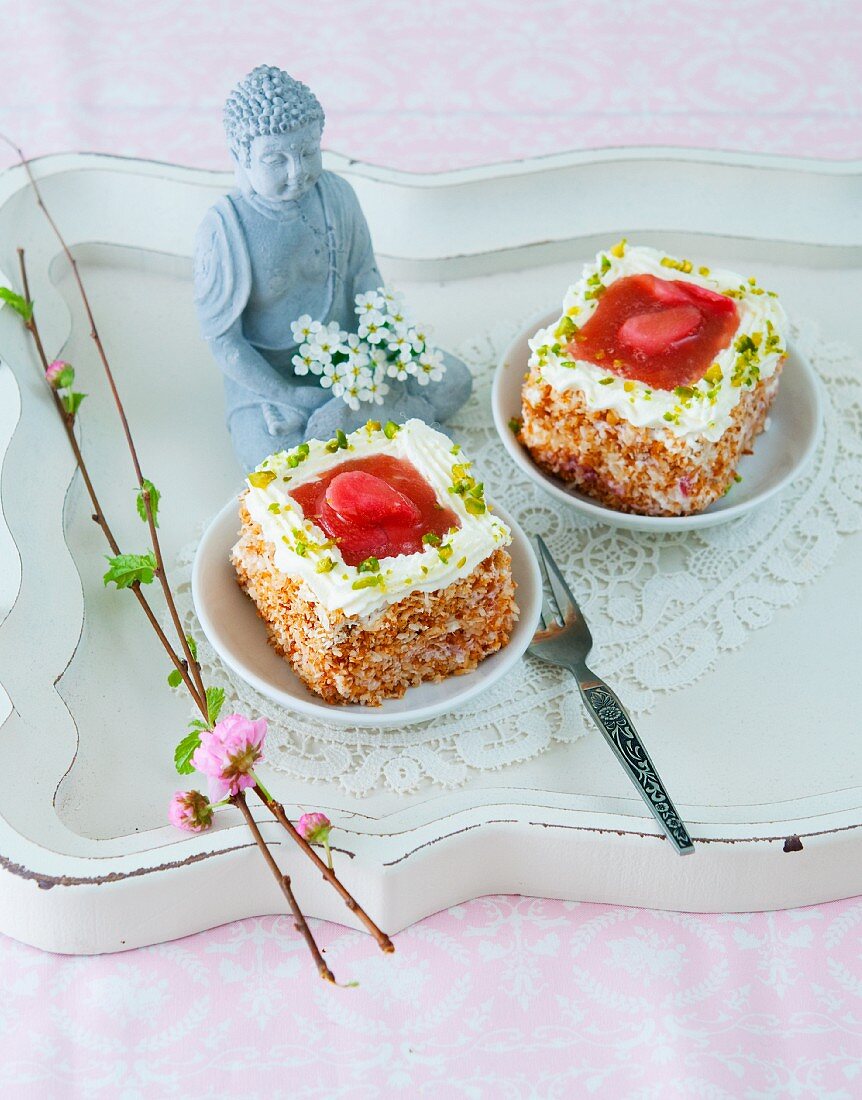 Petit fours with rhubarb and pistachios in front of a Buddha statue