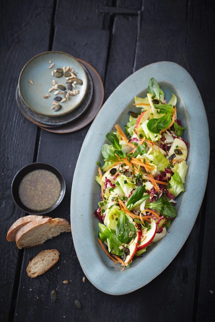 A winter mixed leaf salad with apples and seeds