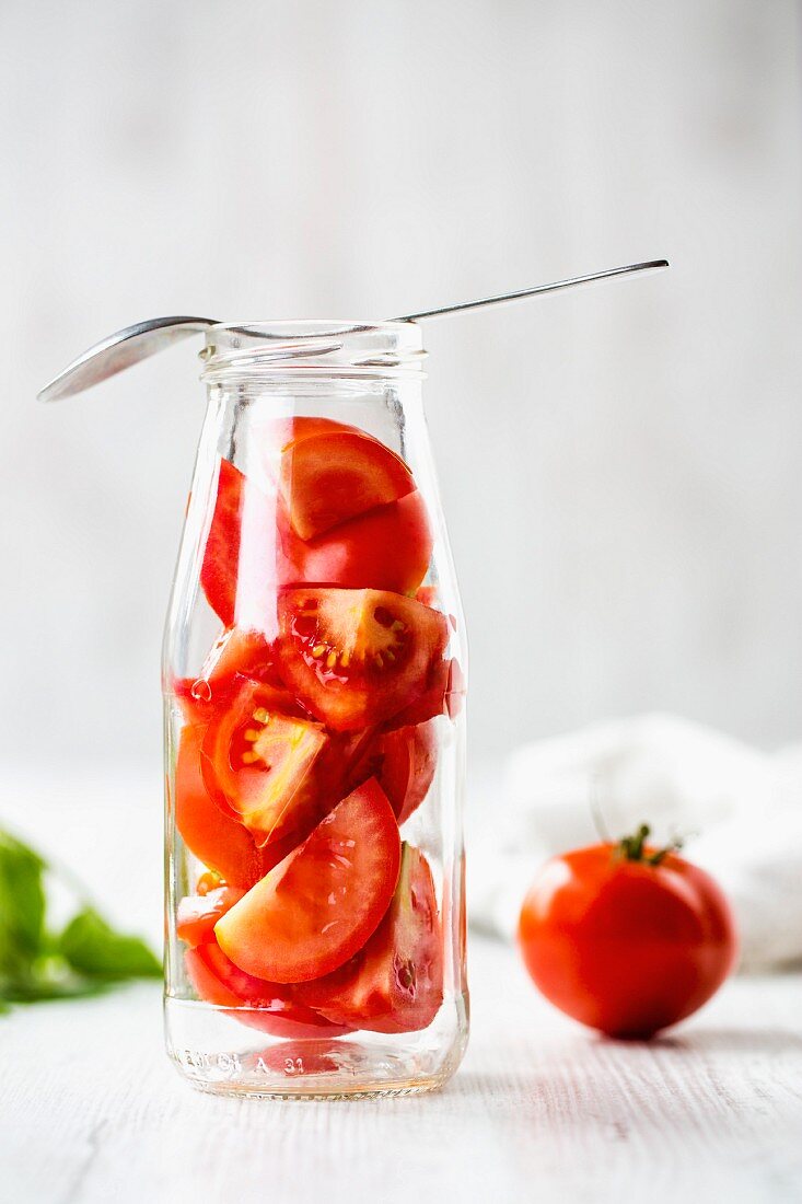 Rote Tomatenstücke in einer Glasflasche