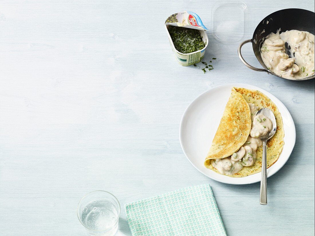 Herb pancakes with mushrooms in a creamy sauce