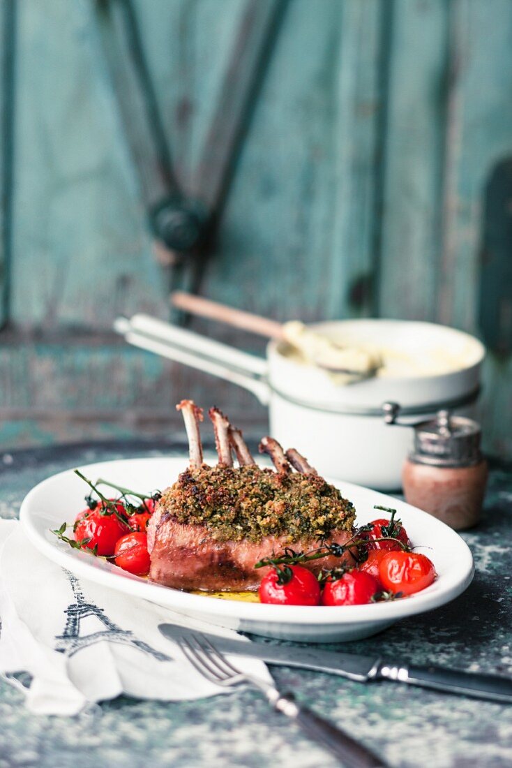Saddle of lamb with a herb crust and oven-roasted tomatoes