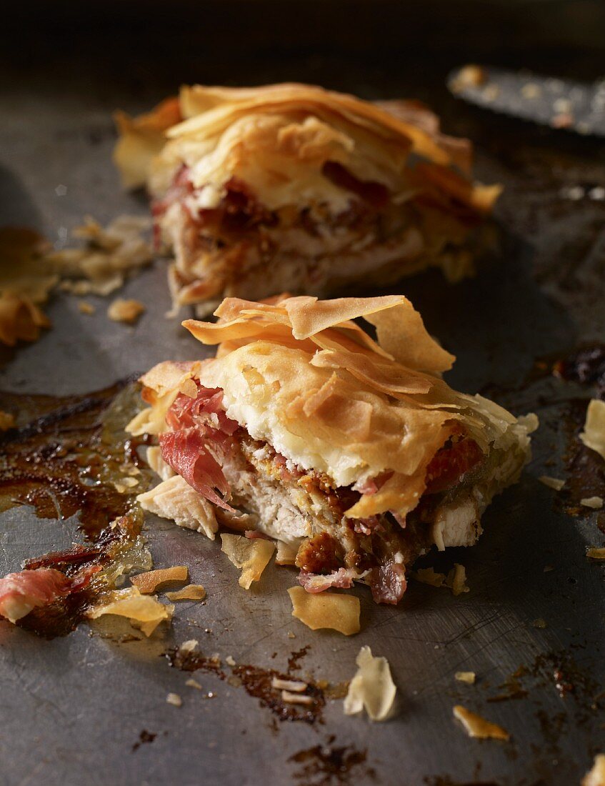Chicken, fig, ham and feta in filo pastry on a baking tray