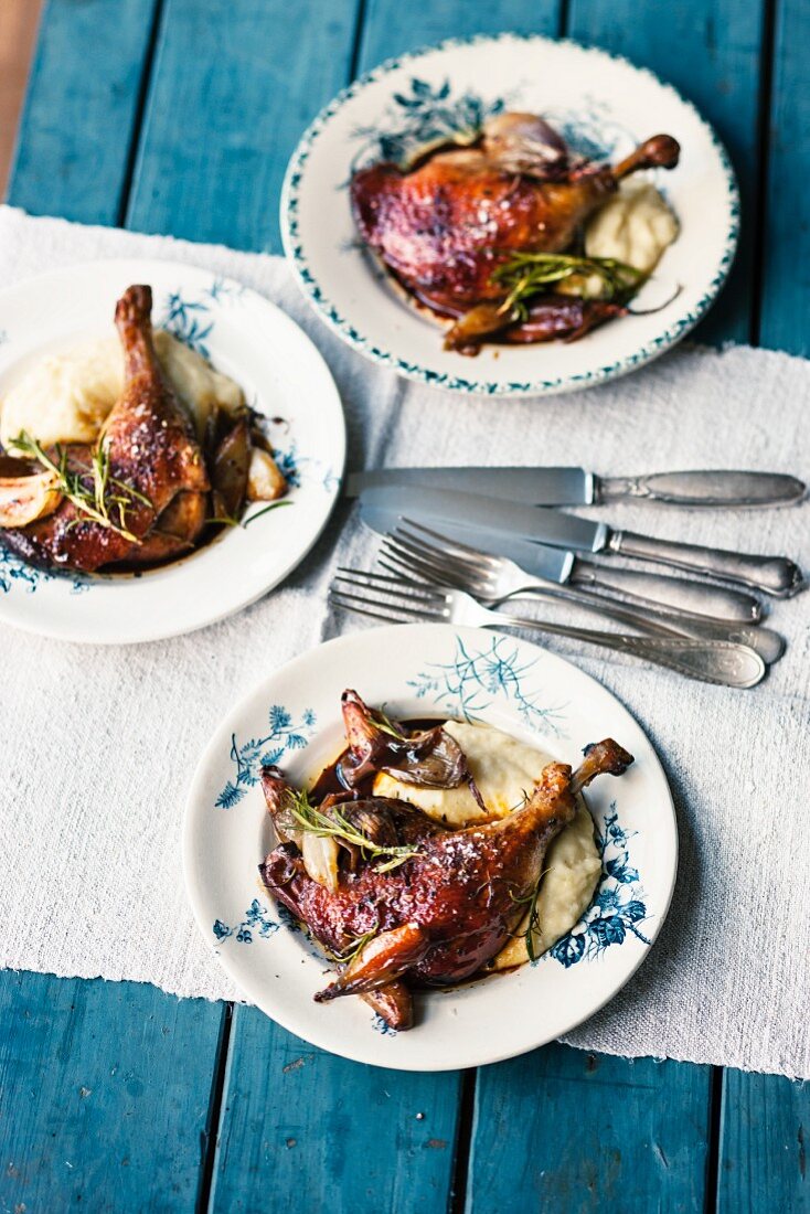 Braised duck legs with shallots on a bed of mashed potatoes