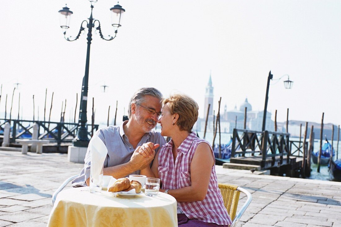 Älteres Paar sitzt in einem Strassencafe in Venedig, Italien