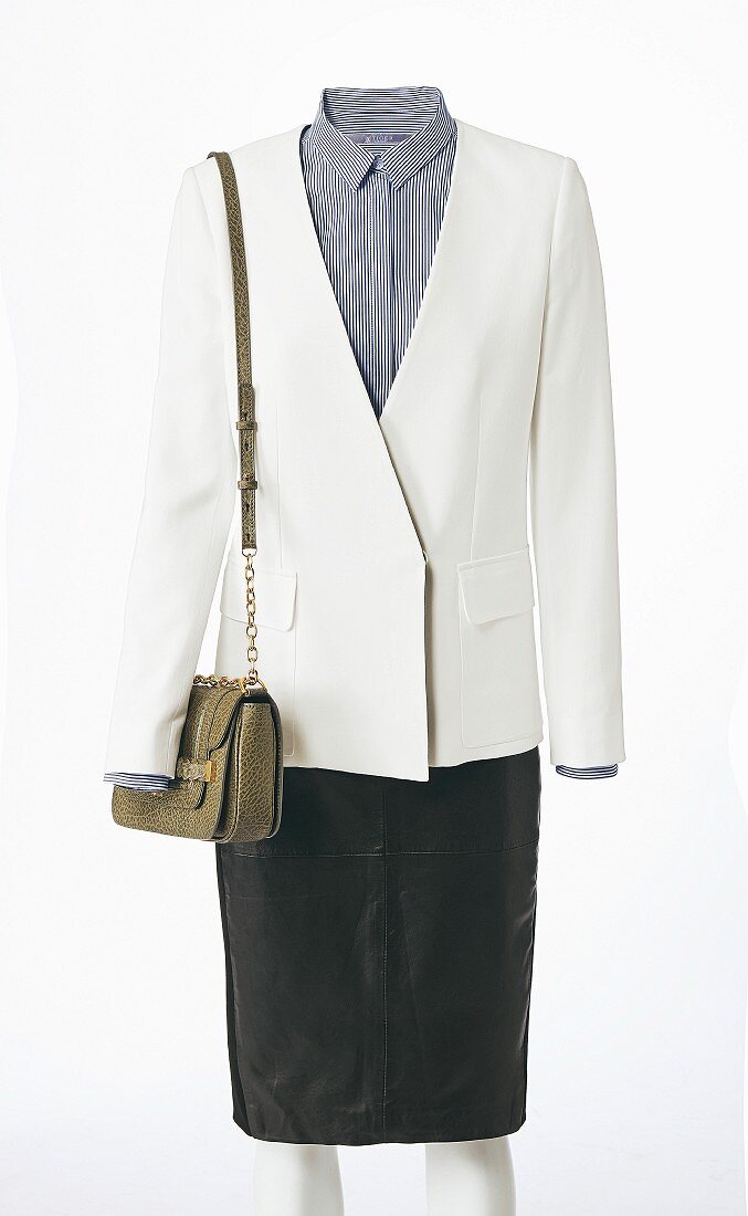 A white blazer with a stripped blouse underneath it, a handbag and a black A-Line skirt