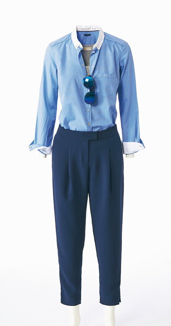 A blue blouse, pleated trousers and a pair of sunglasses