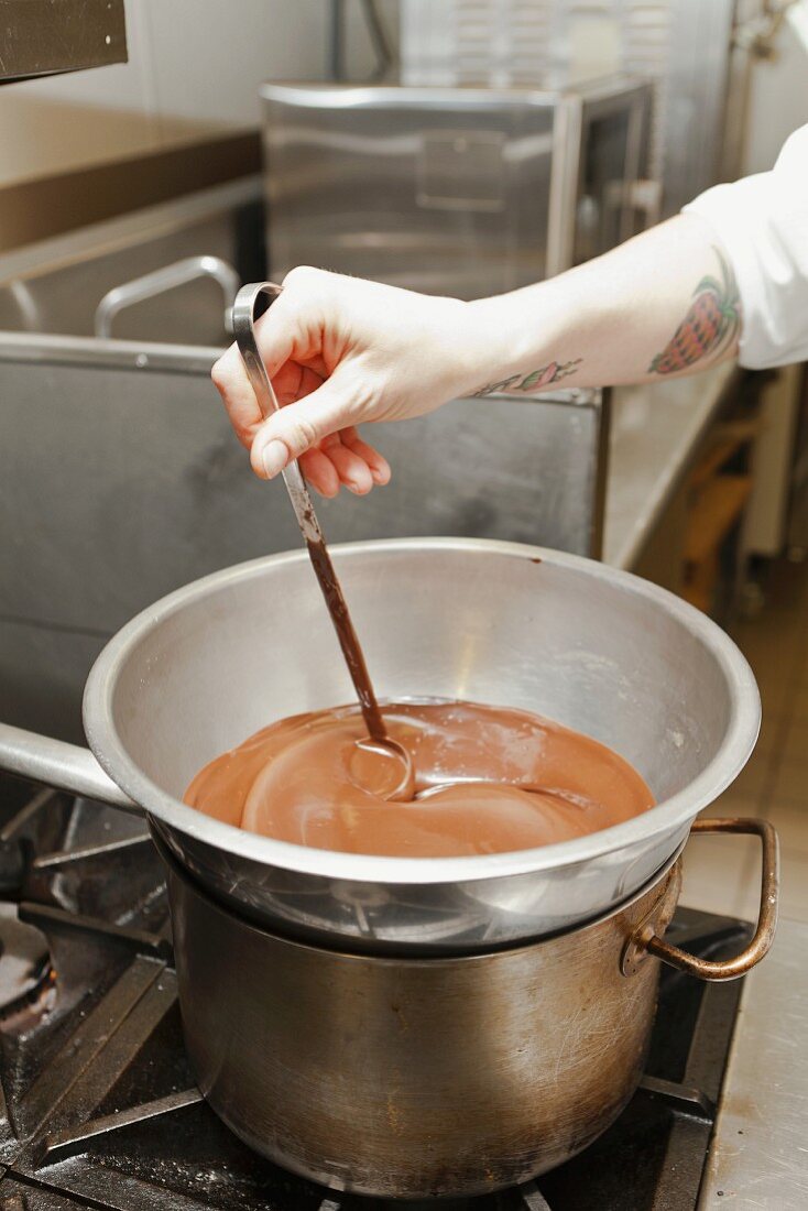 A chef stirring melted chocolate