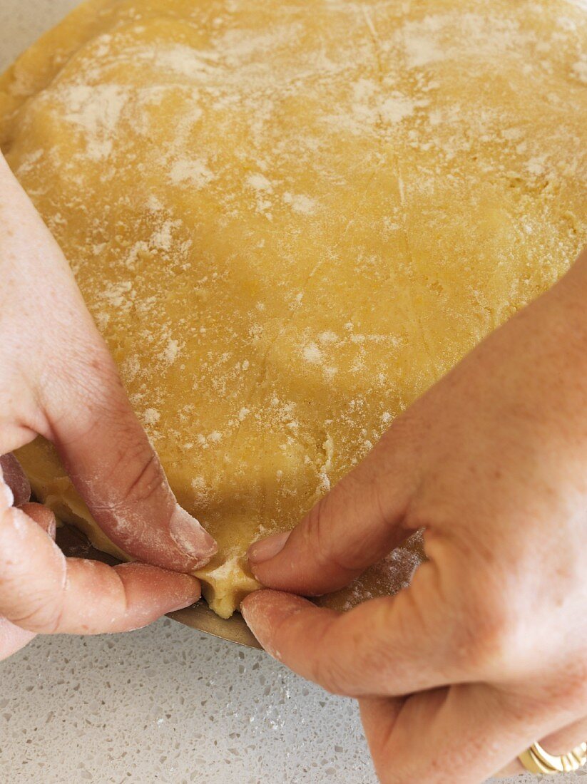 The edge of an apple pie being crimped