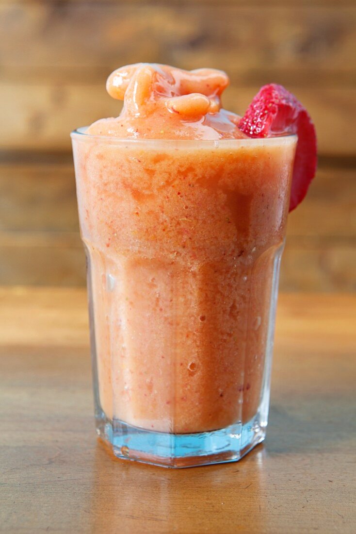 A peach smoothie made with apple juice, oranges and strawberries