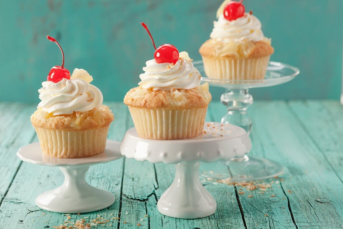 Pina colada muffins with cream and glace cherries