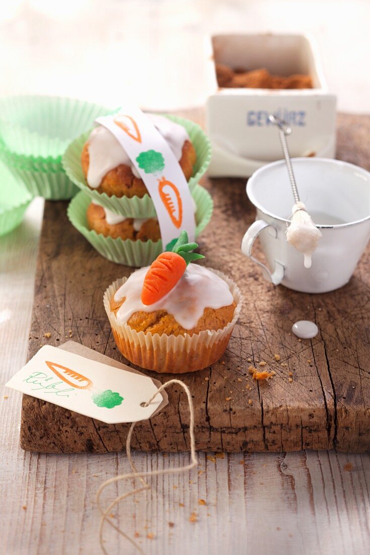 Carrot cake muffins with icing sugar and marzipan carrots