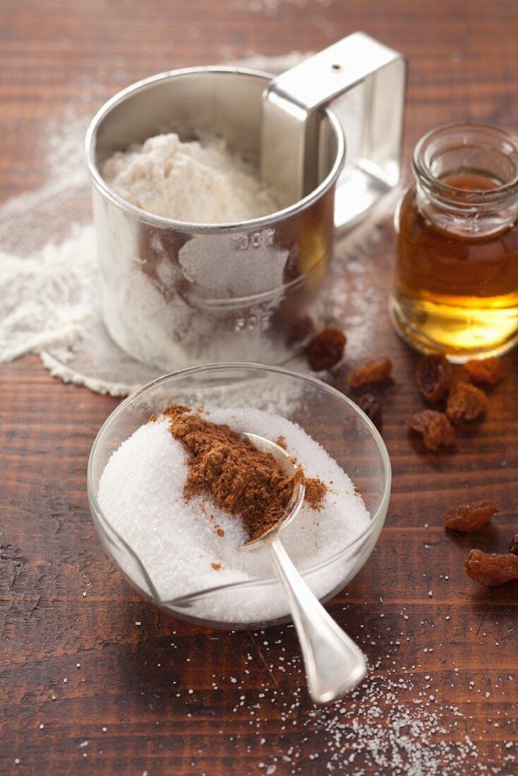 Baking ingredients: flour, sugar, cinnamon, honey and raisins