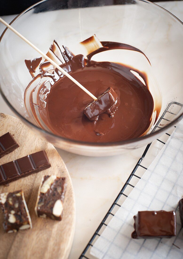 Confectionery being covered with tempered chocolate