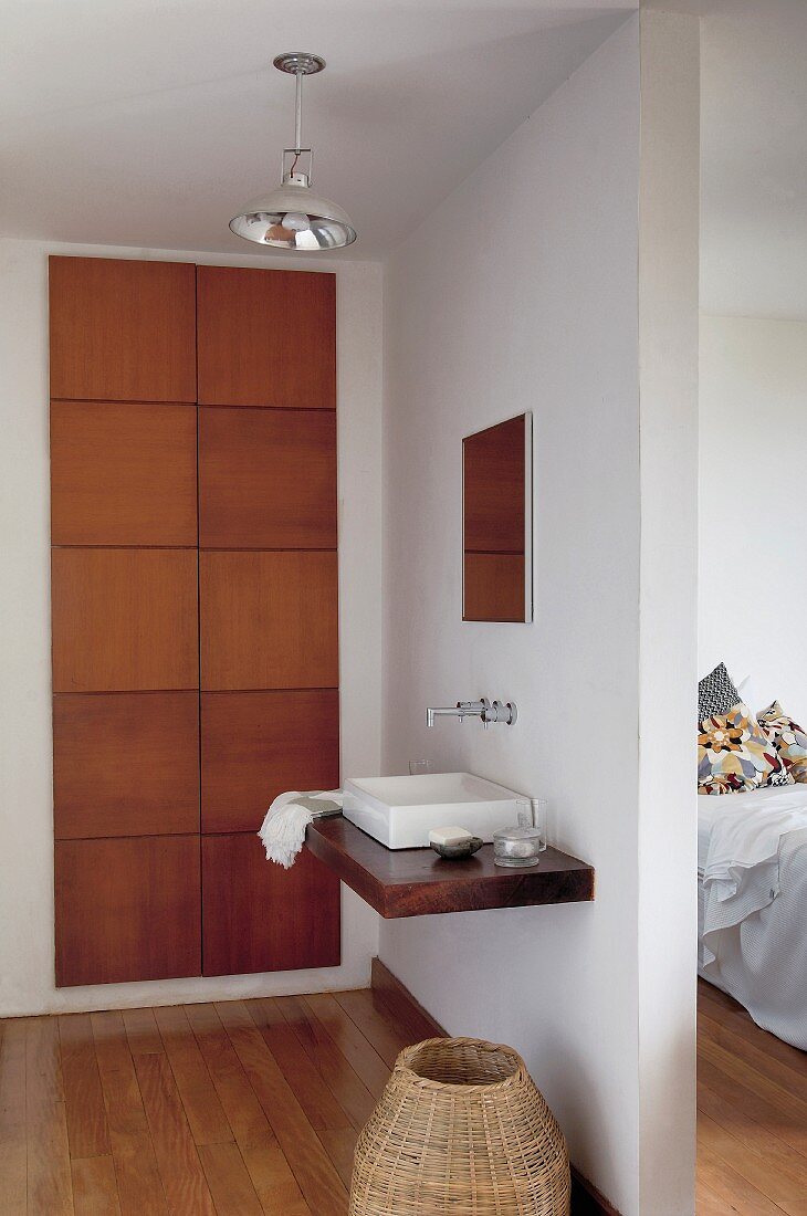 Waschbereich - an Raumteiler montierter Waschtisch mit Wandarmatur, seitlich Einbauschrank mit Massivholztüren