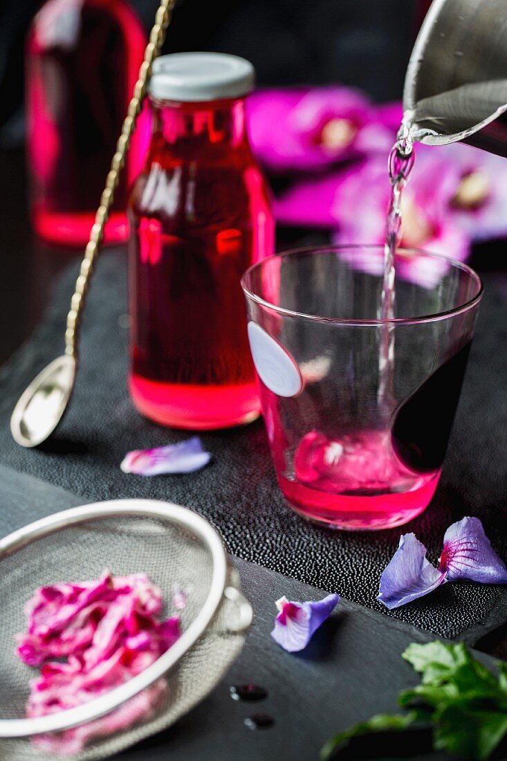 Hibiskusblütensirup zubereiten (Wasserglas, Sirupflasche, Hibiskusblüten)