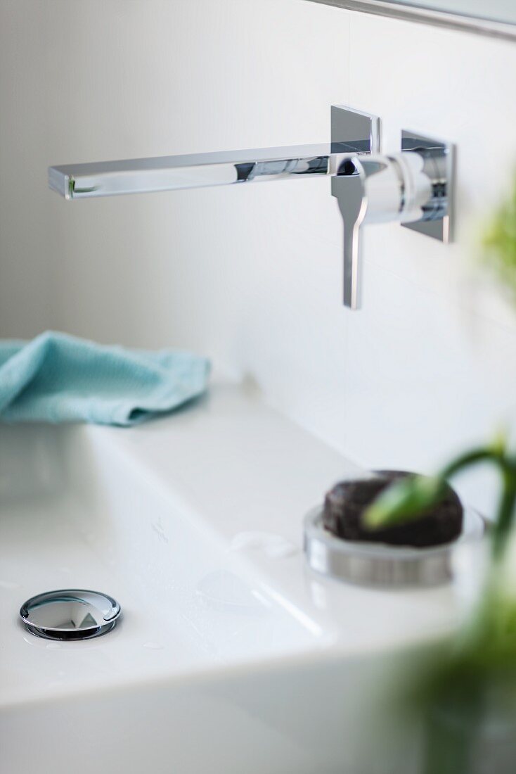 A modern wall and a wash basin with a straight-edged design