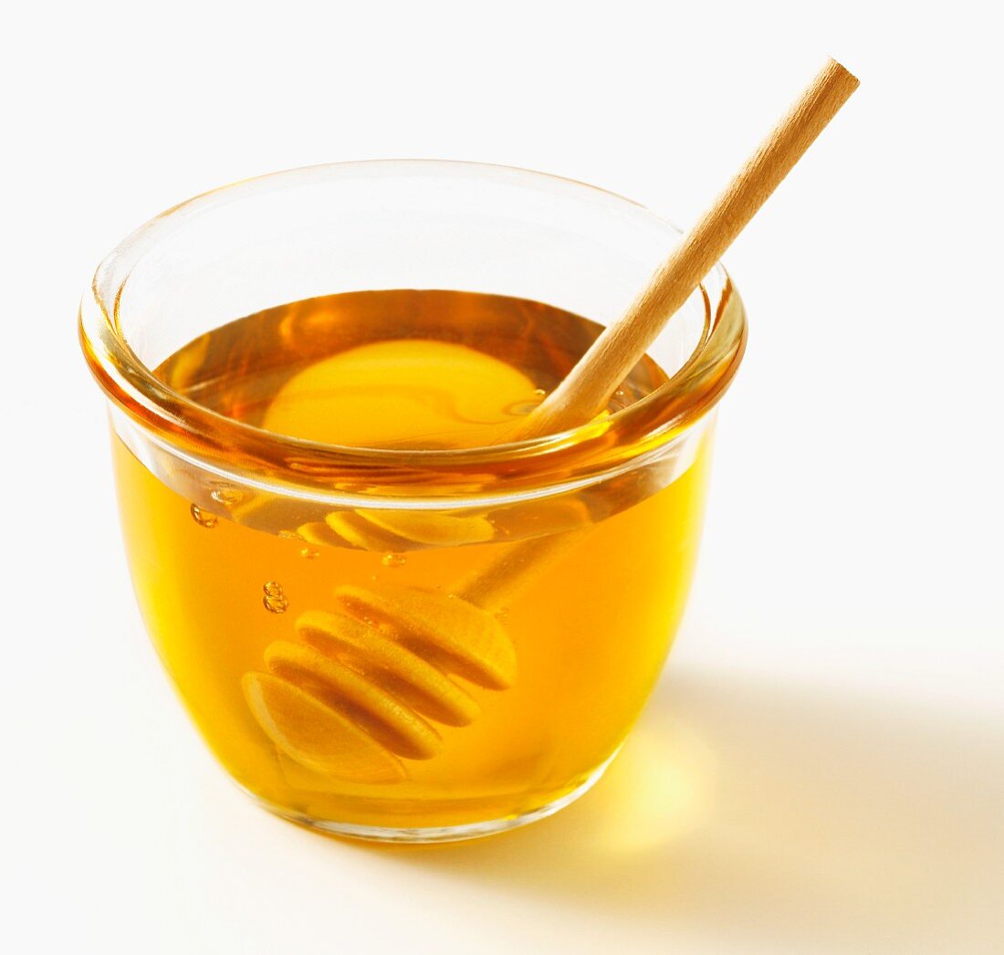 Honig im Glasschälchen mit Holzlöffel