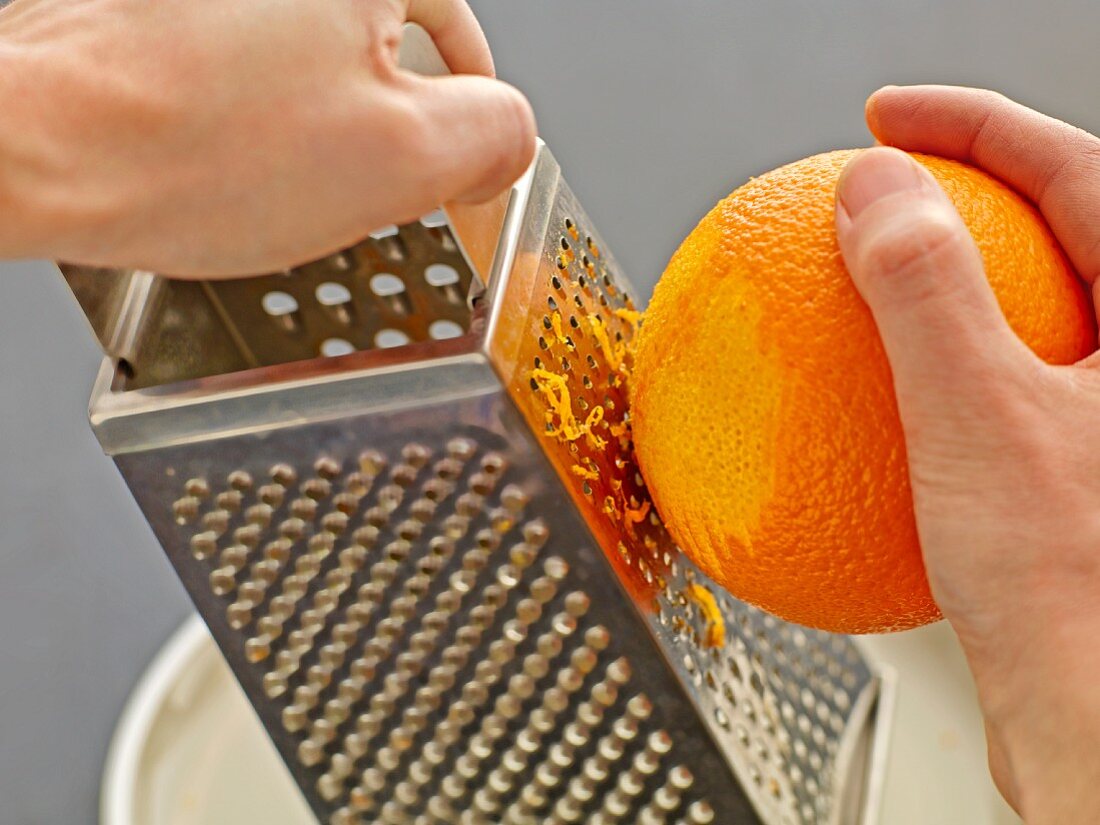 An orange being grated