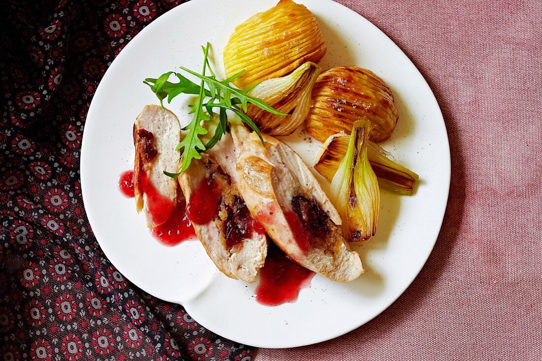 Hähnchenfilet mit Orangen-Cranberry-Sauce, dazu Zwiebeln und Kartoffeln