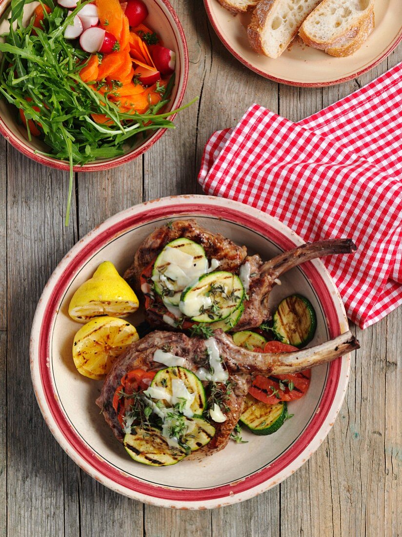 Gegrillte Kalbskoteletts mit Gemüse, Salat und Weißbrot