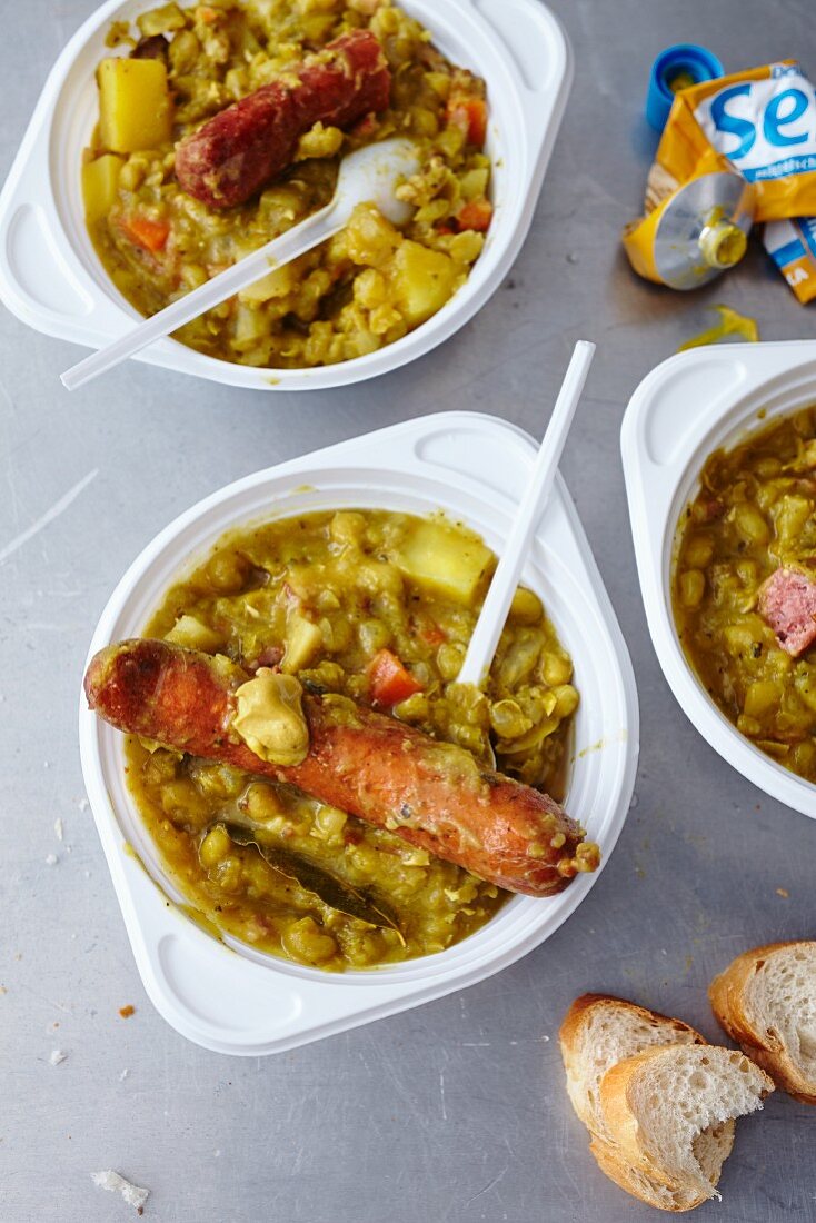 Pea soup with sausages in disposable bowls