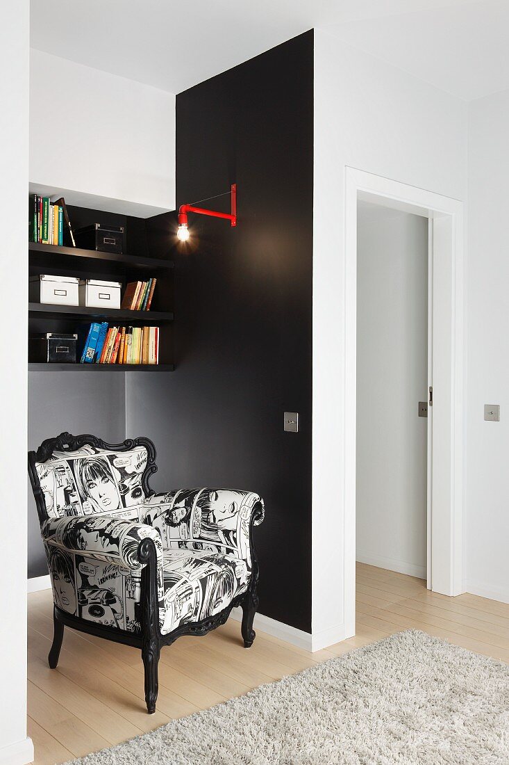 Postmodern armchair with black and white cover in black-painted niche below shelves