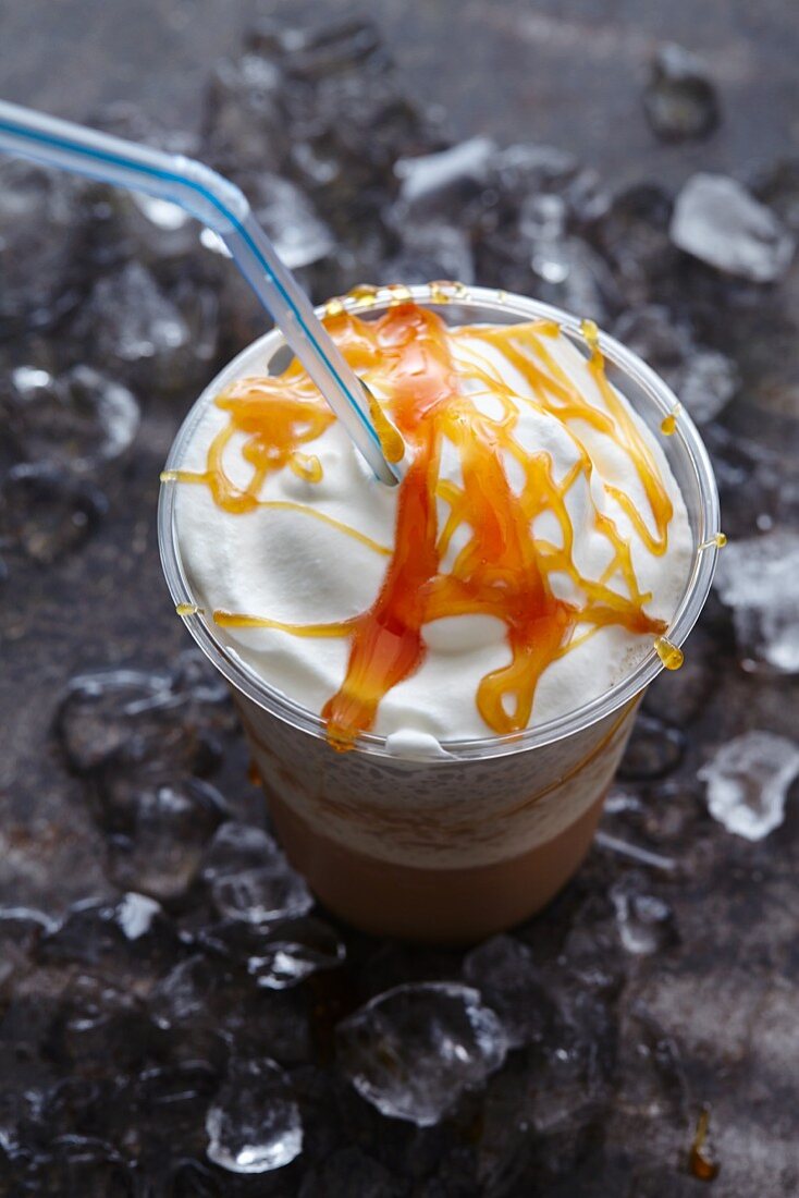 Mocha iced coffee with cream and caramel sauce in a plastic cup