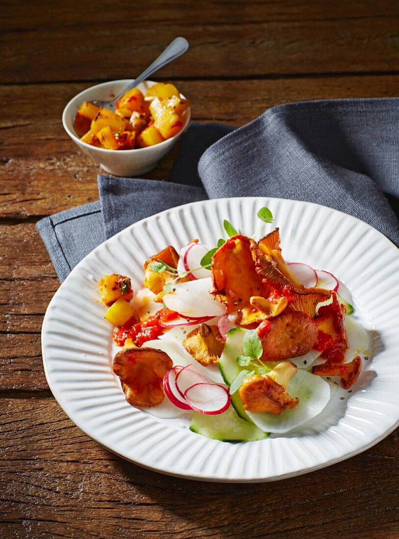 Chanterelle mushrooms with sliced radish and horseradish, cucumber and red pesto