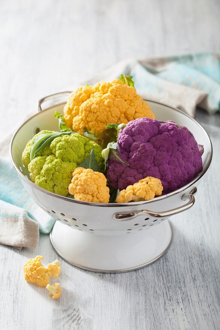 Different coloured cauliflower in a colander