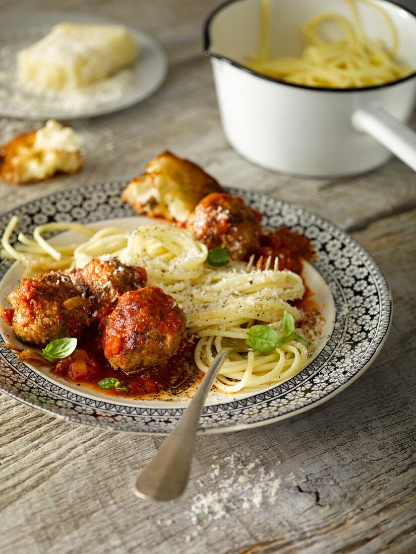 Spaghetti with meatballs served with bread and grated cheese