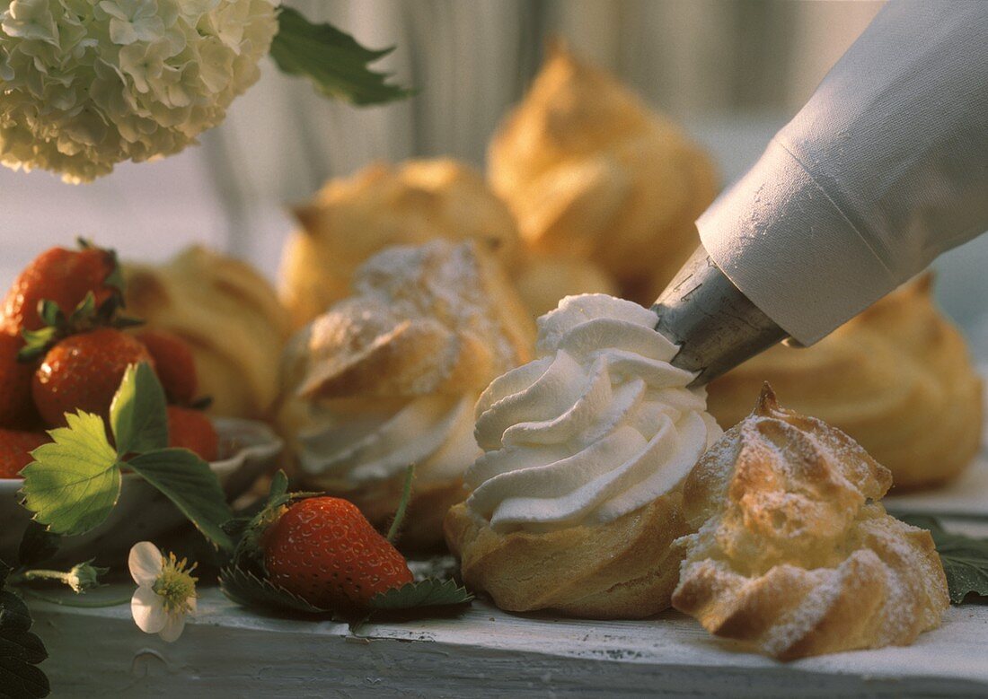 Filling cream puffs with whipped cream using a piping bag