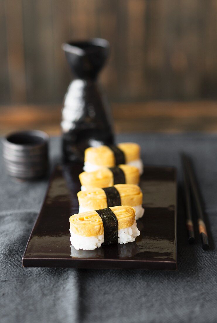 Tamago-Nigiri-Sushi auf schwarzer Lackplatte