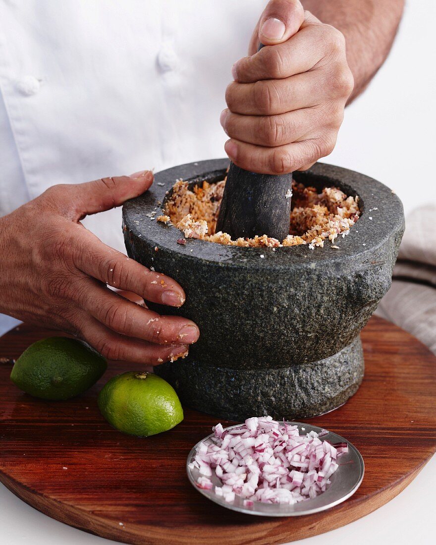 Ingredients for curry being crushed in a mortar