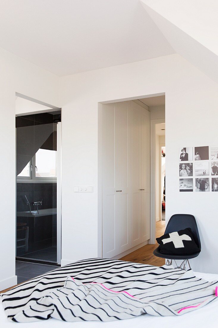 Striped bedspread on bed and classic chair in attic sleeping area