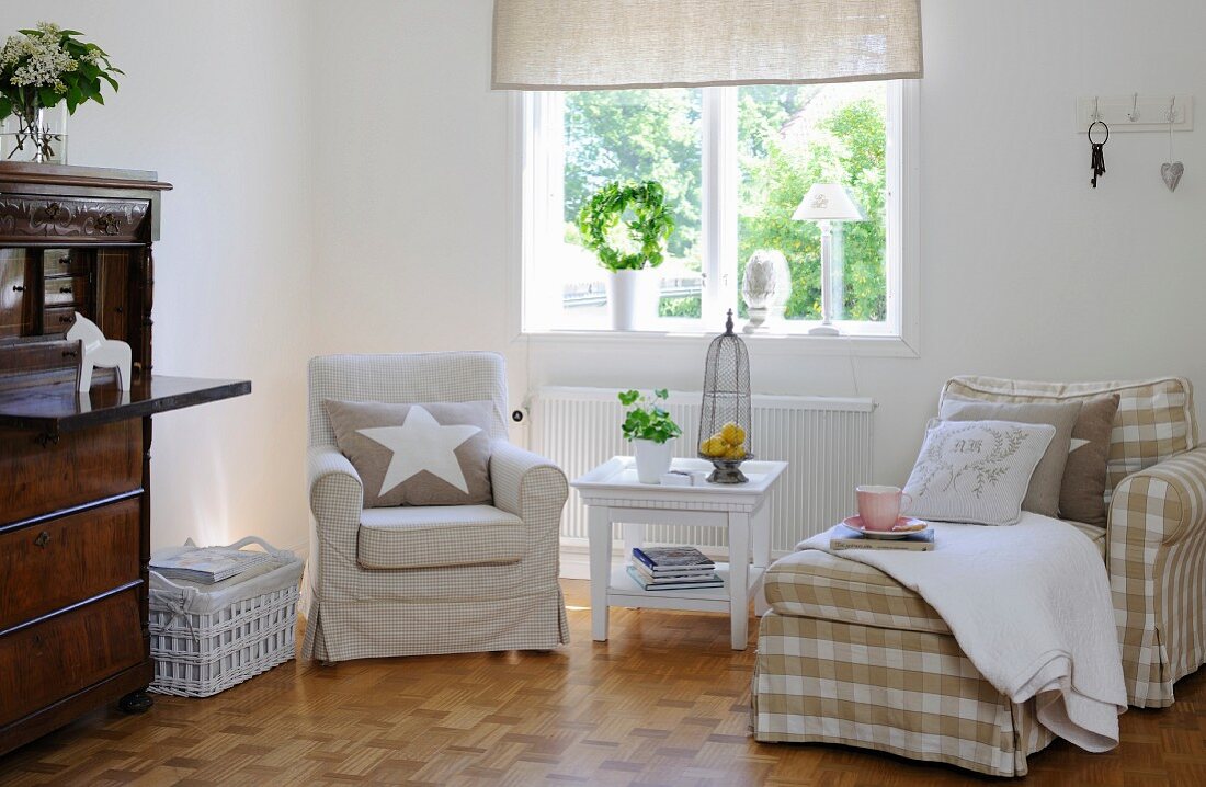 Armchairs with gingham loose covers below window in living room