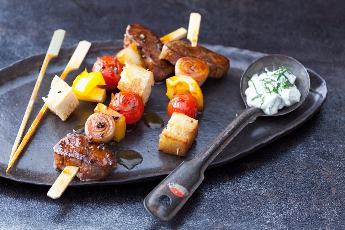 Lamb and bread skewers on a hot stone