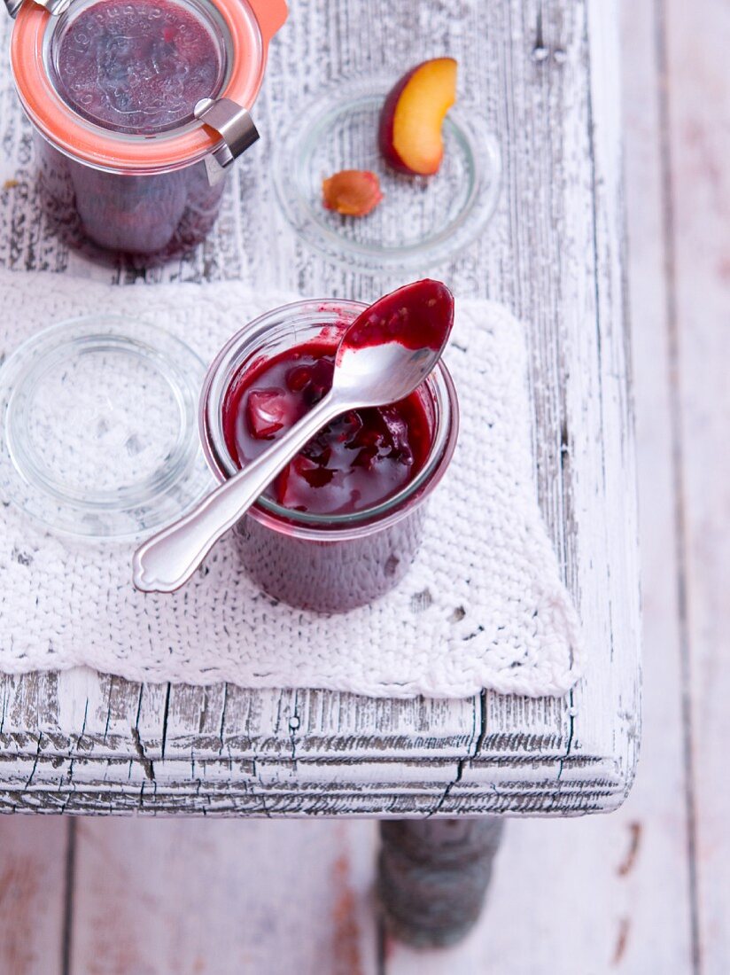 Peach and raspberry jam with a jar of plums