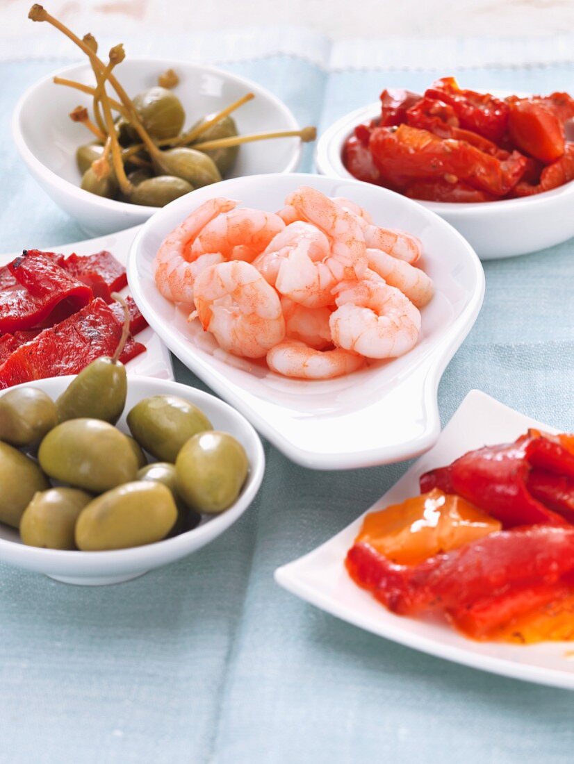 Various types of antipasti (prawns, olives, peppers and giant capers)