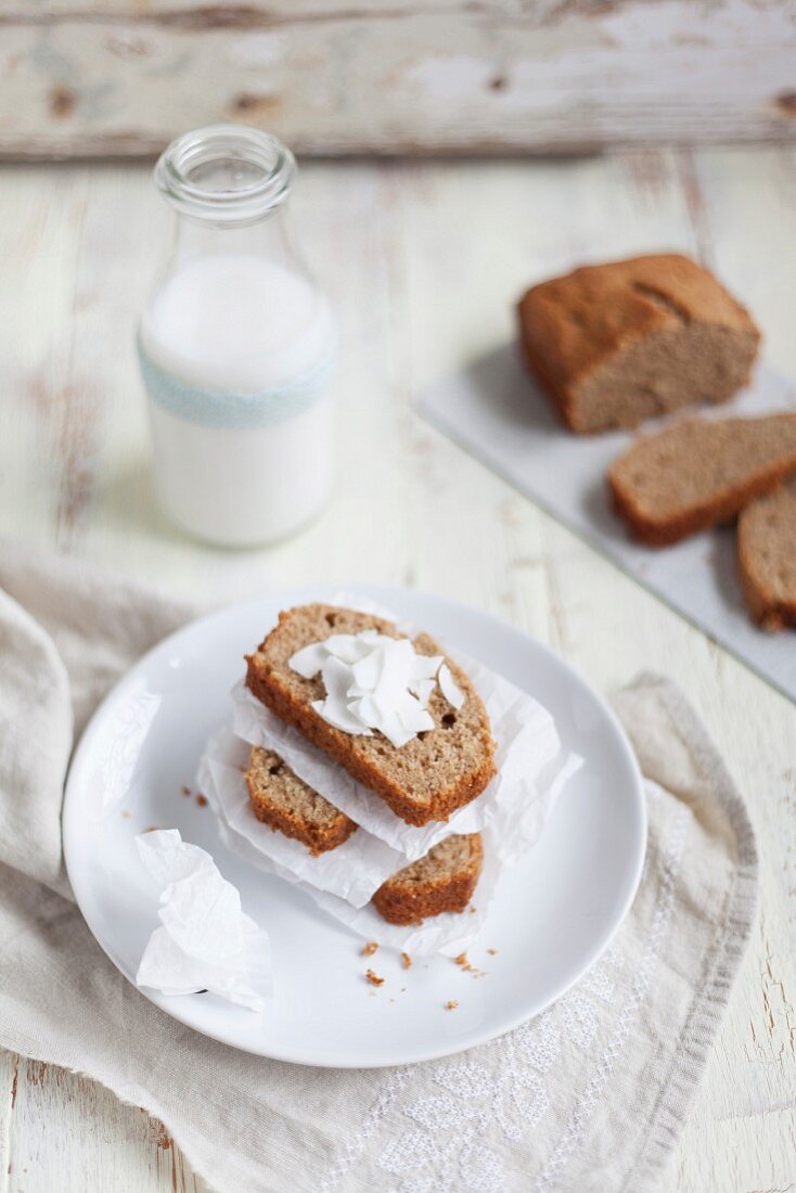 Bananenbrot mit Kokosflocken vor Milchflasche