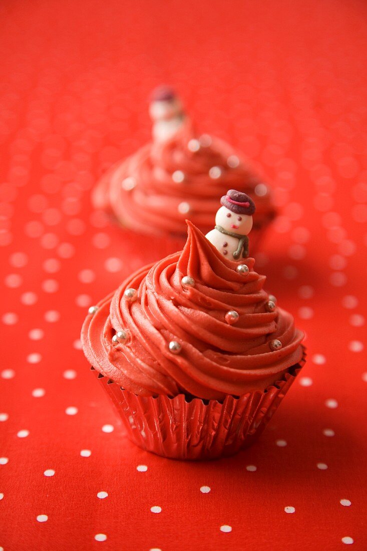 Red Christmas cupcakes decorated with silver pearls and snowmen