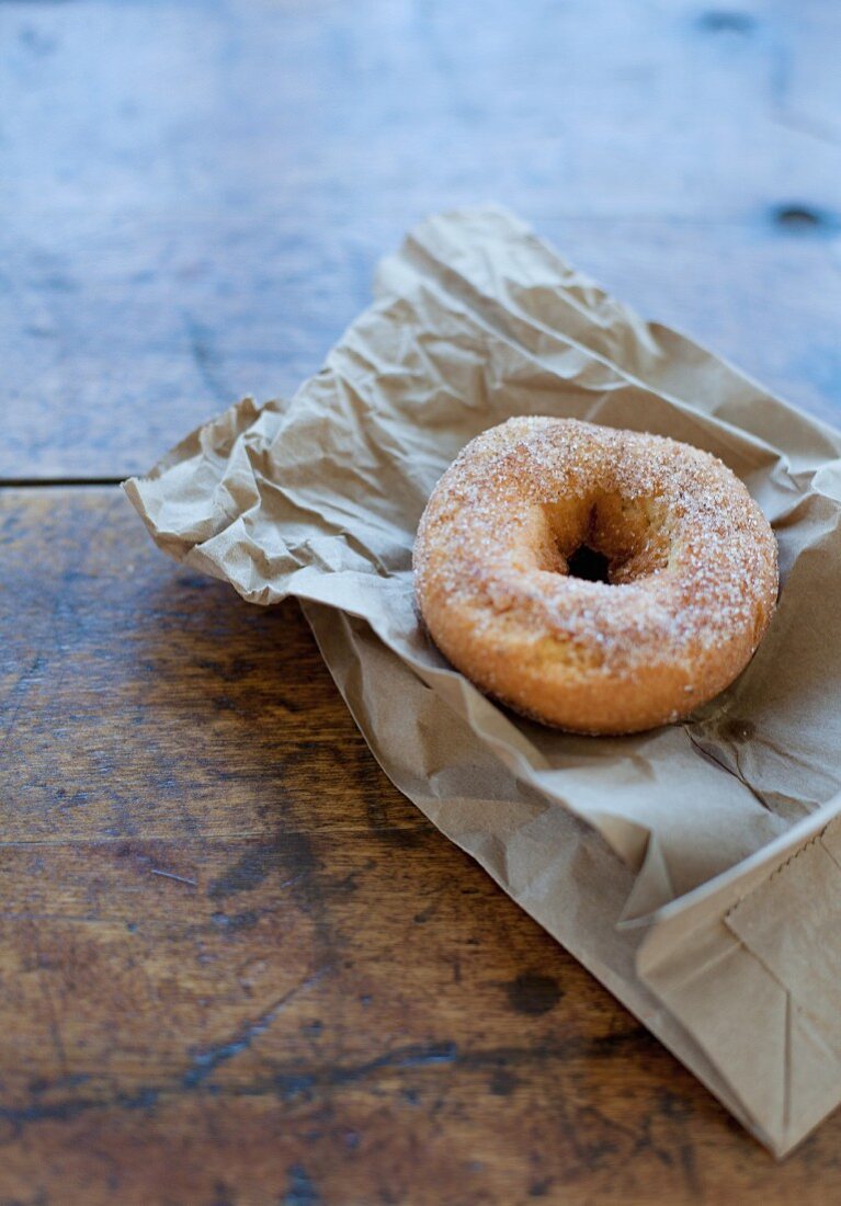 Doughnut mit Zimtzucker auf Papiertüte