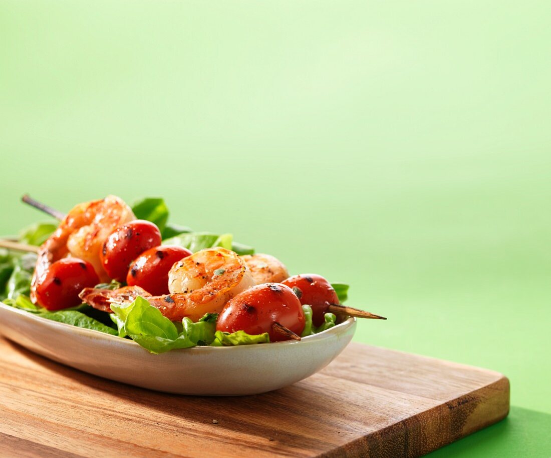 Prawn skewers with tomatoes on a bed of lettuce