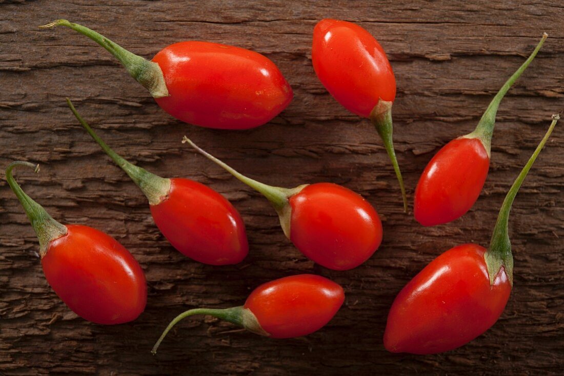 Bright red goji berries on a rustic wooden surface