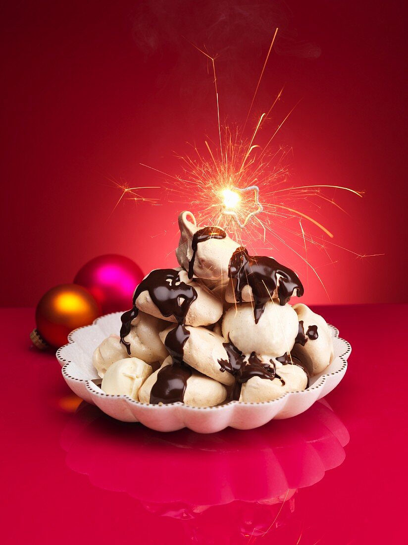 Schokoladenbaisers mit Schokosauce und Wunderkerze zu Weihnachten