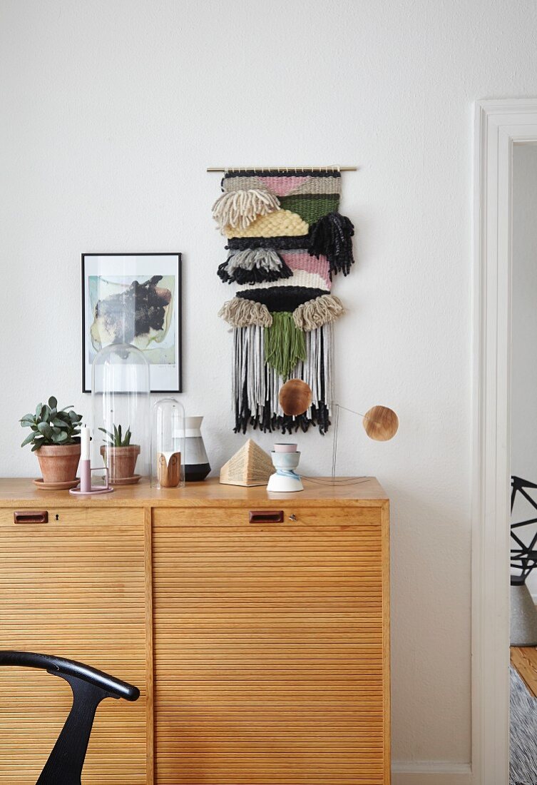 Hand-woven, decorative wall-hanging above sideboard