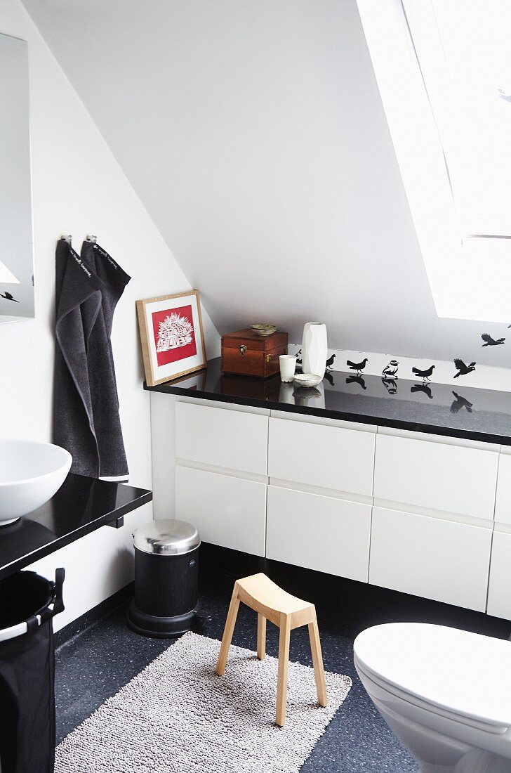 Modernes, weisses Badezimmer mit Einbauschrank unter Dachschräge und Wandtattoos mit Vogelmotiven und schwarzen Accessoires