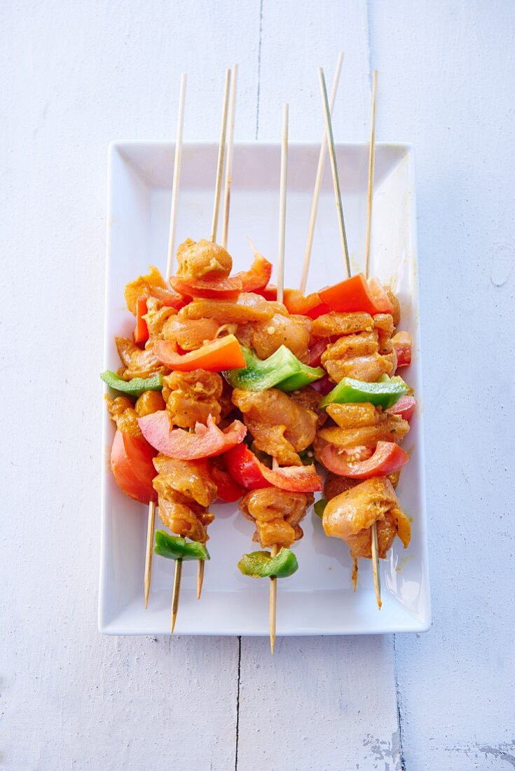 Raw chicken and pepper skewers marinated in honey and curry