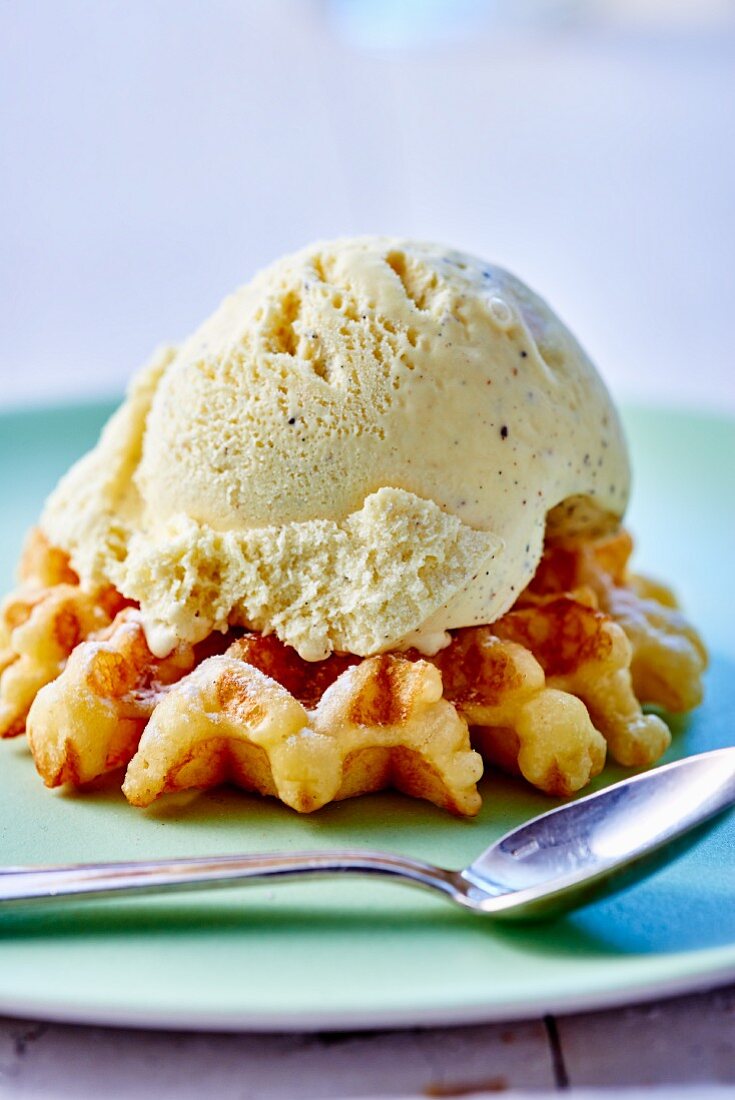 A fresh waffle with a scoop of vanilla ice cream